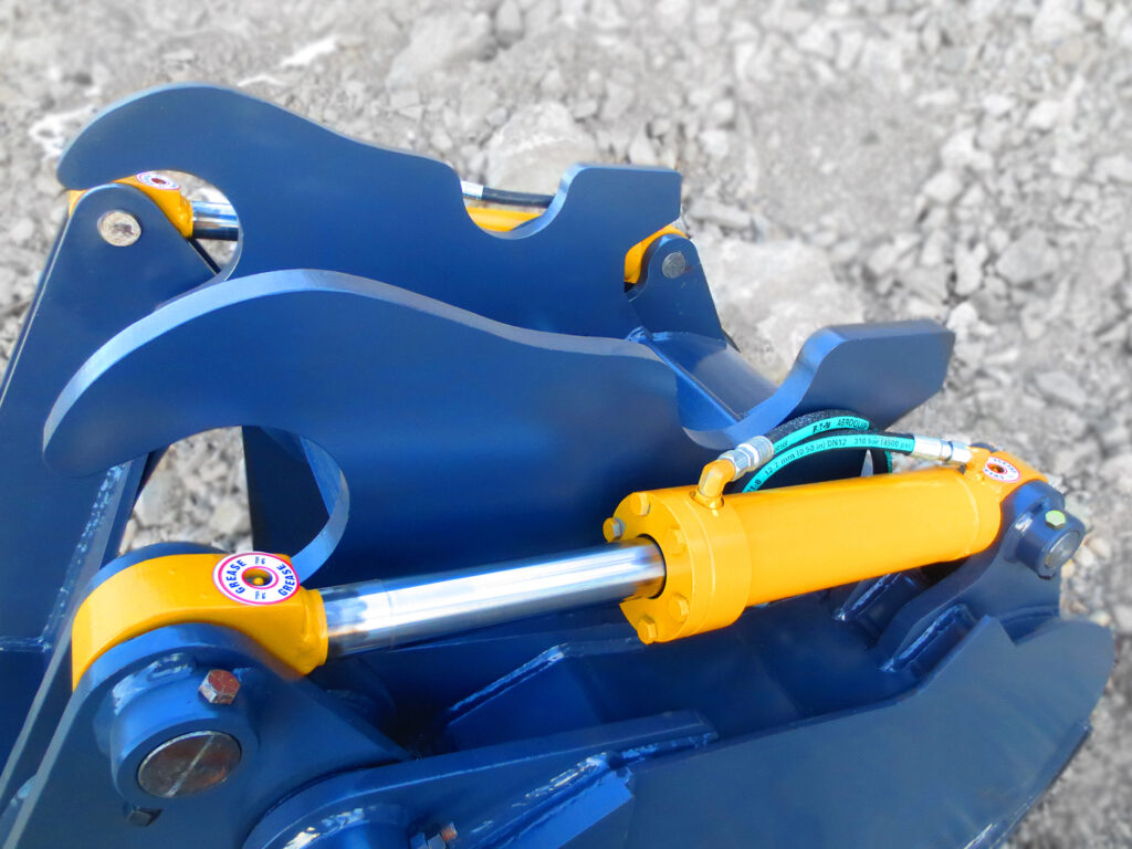 Dual hydraulic cylinders installed on an excavator grapple arm bucket.  Heavy duty hydraulic excavator cylinders